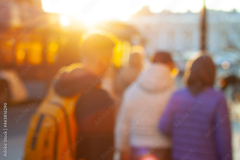 Blurred background with people walking around the city at golden hour