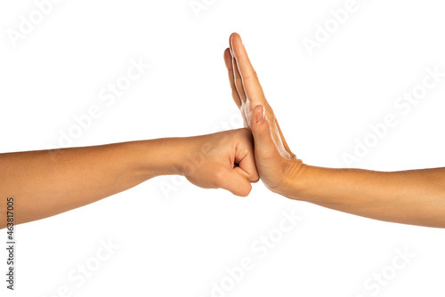 Woman's fist against woman's open palm, isolated on white.