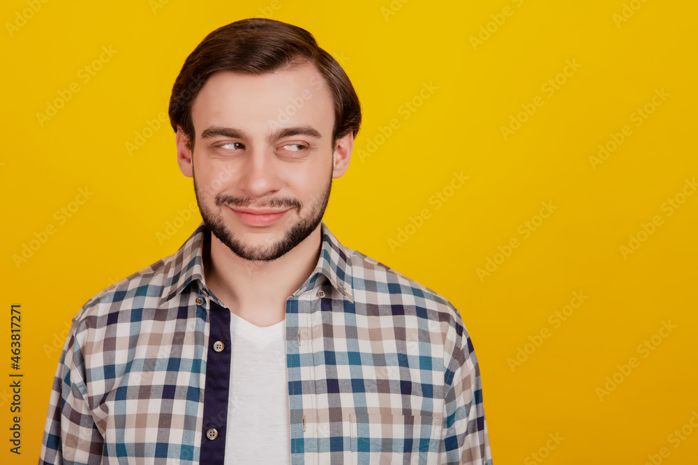 Photo of young man happy positive smile look empty space curious interested isolated on yellow color background Photo of young man happy positive smile look empty space curious interested isolated on yellow color background