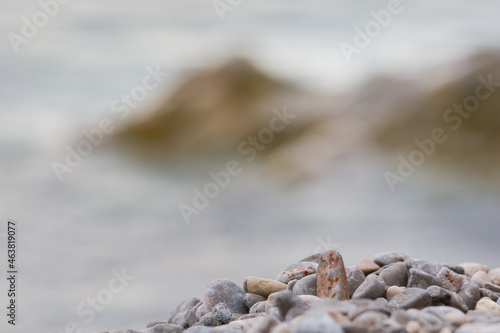 close up of stones on beach with blurry background and space for text