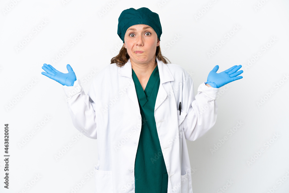 Surgeon caucasian woman in green uniform isolated on white background having doubts while raising hands Surgeon caucasian woman in green uniform isolated on white background having doubts while raising hands