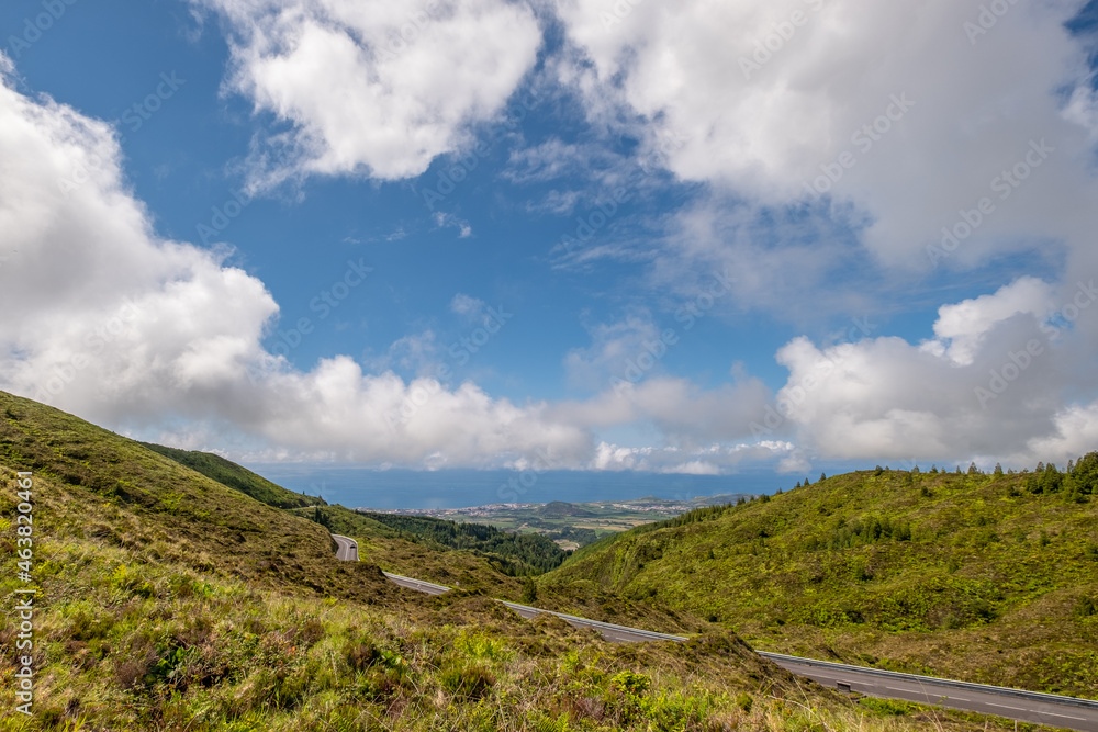 Road with beautiful view to the north coast of the island and the green vegetation near the Fire Lagoon (Lagoa do Fogo) on a summer day afternoon. São Miguel Island in the Azores.