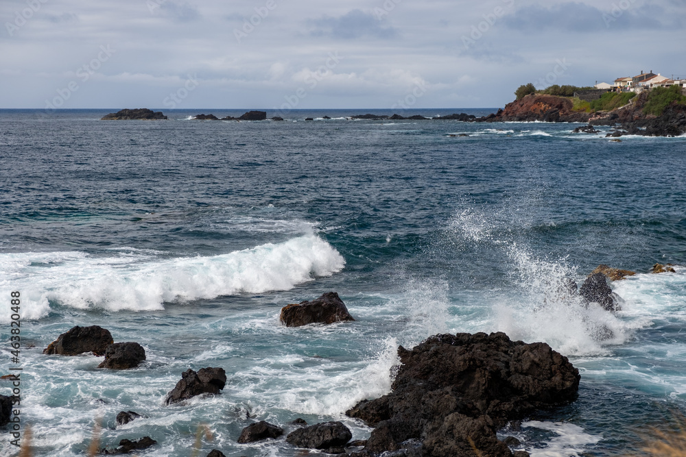 Small waves splashing the volcanic rocks in the Atlantic Ocean. São Miguel island, Azores, Portugal.
