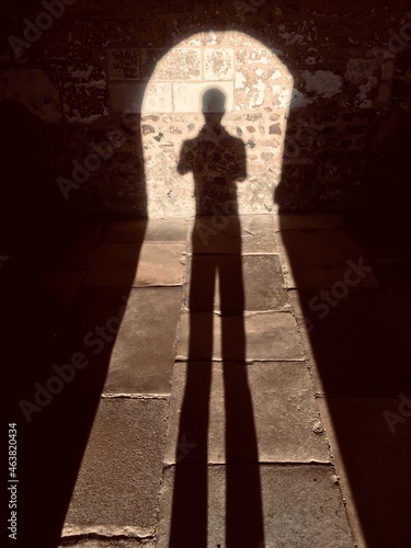 silhouette of a person in a doorway with old flagstones