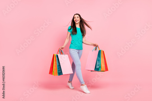 Full length profile side photo of young woman happy positive smile walk buy shop discount isolated over pastel color background