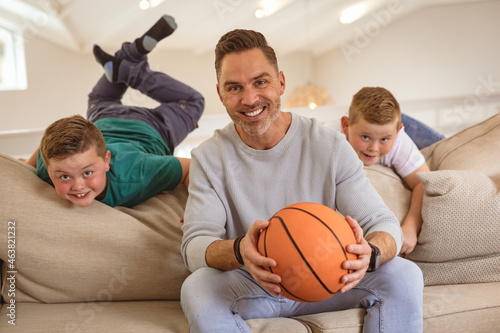 Portrait of caucasian father and two sons with basketball smiling at home © WavebreakMediaMicro