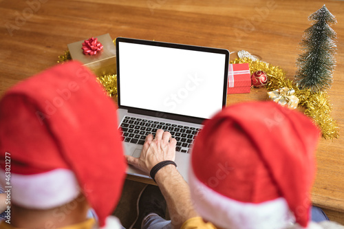 Rear view of father and son using laptop with copy space at home during christmas