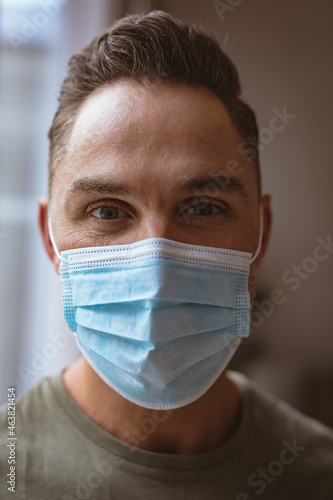 Close up view of caucasian man wearing face mask at home