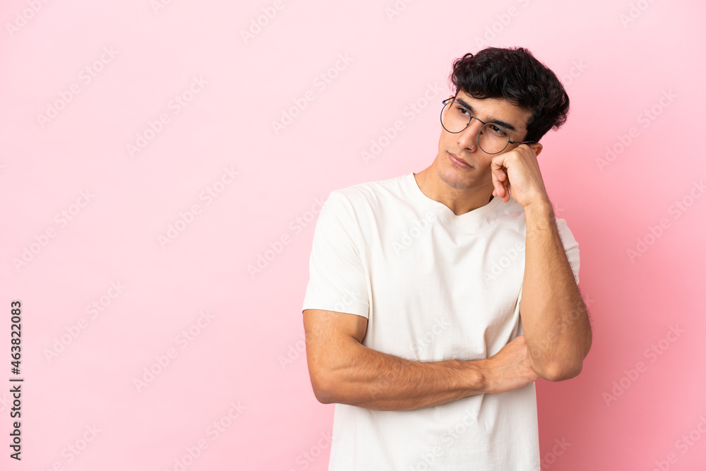 Young Argentinian man isolated on pink background with tired and bored expression Young Argentinian man isolated on pink background with tired and bored expression