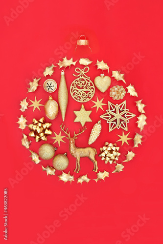 Abstract Christmas bauble concept shape with gold tree decorations on red background. Composition for the festive season. Flat lay  top view  copy space.