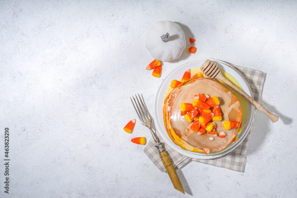Homemade candy corn pancakes. Stack of yellow and orange pancakes with sweet sauce and traditional Halloween candy cord candies Homemade candy corn pancakes. Stack of yellow and orange pancakes with sweet sauce and traditional Halloween candy cord candies