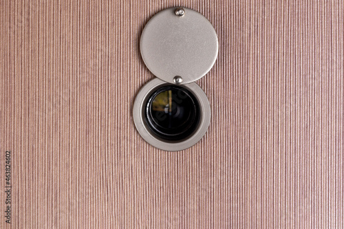 peep hole lens on wooden texture.