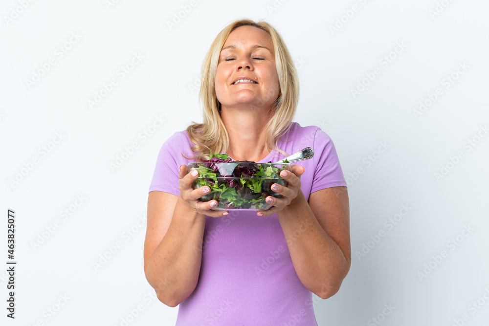 Middle age Lithuanian woman isolated on white background holding a bowl of salad with happy expression Middle age Lithuanian woman isolated on white background holding a bowl of salad with happy expression