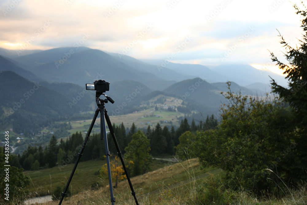 Taking video with modern camera on tripod in mountains