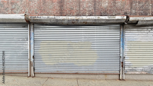 Photography Plain steel roller window shutters with paint on a closed brick building in the