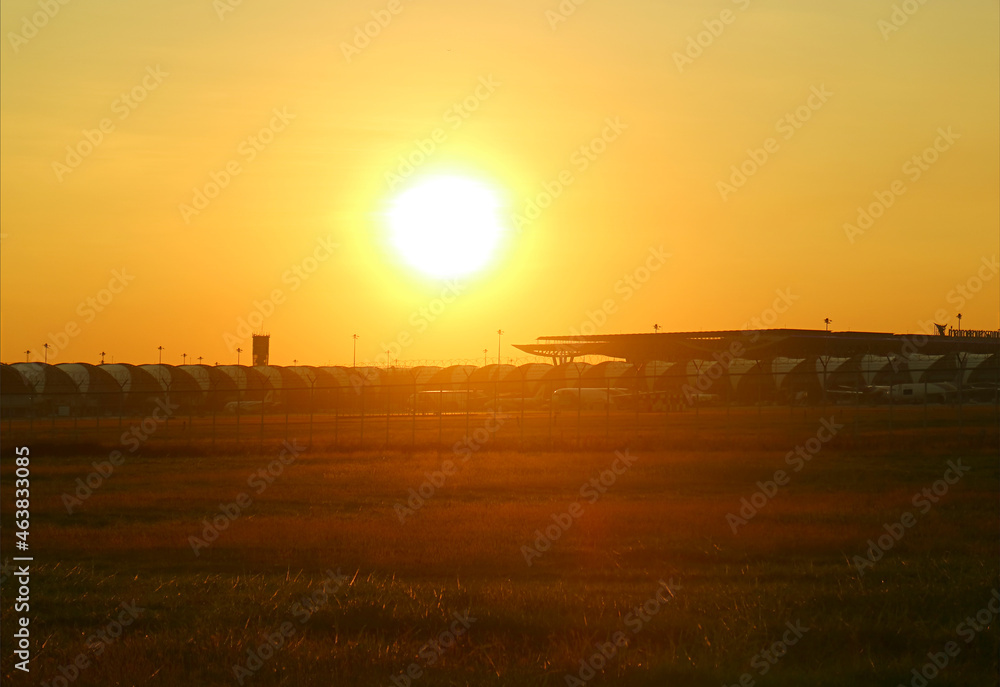 Stunning bright sun over a golden grass field outside the airport