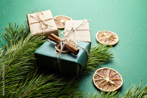 Christmas gift boxes and pine tree branches with decoration on green