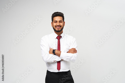 Portrait of young indian top manager in t-shirt and tie crossed arms and smiling on white isolated background