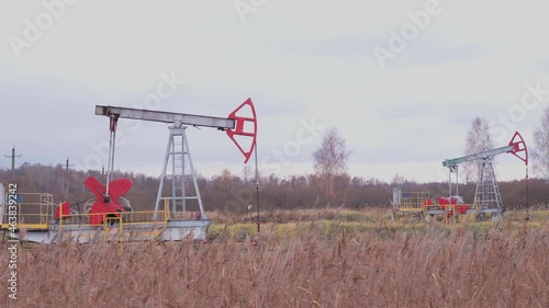 Oil production in Russia. Oil rockers work on the oil field in the autumn.