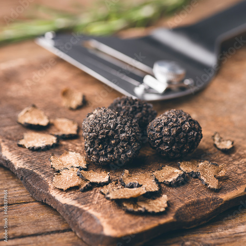 Billede på lærred Autumn black truffles mushrooms and truffles knife on rustic wooden table, squar