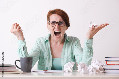 Tableau sur toile A young woman with glasses in a rage crudged the paper sheets