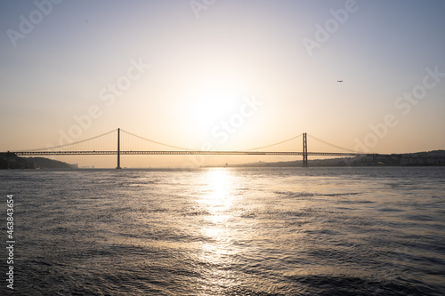 Sunset in the middle of a river with a majestic bridge © carles