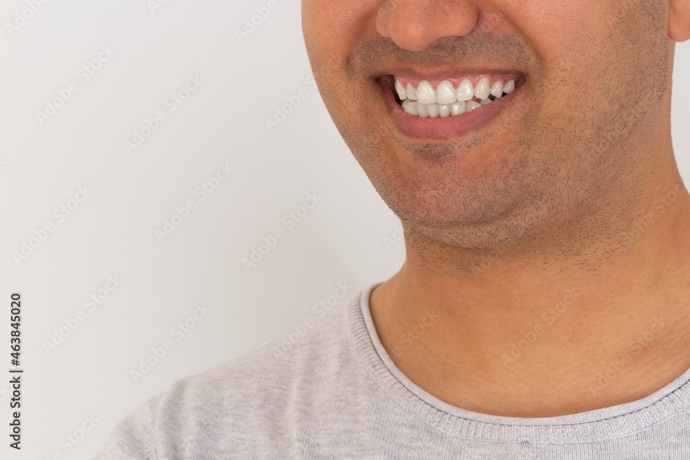 Close up photo of brown skinned young adult man smiling. White teeth concept. Close up photo of brown skinned young adult man smiling. White teeth concept.