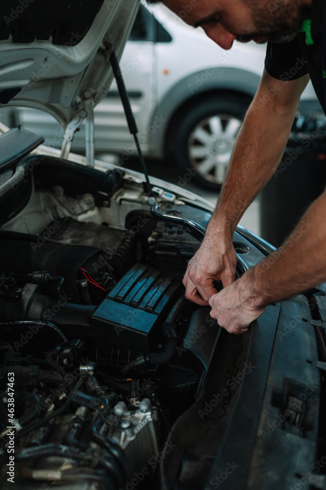 Fototapeta premium Car mechanic in a workshop working at car