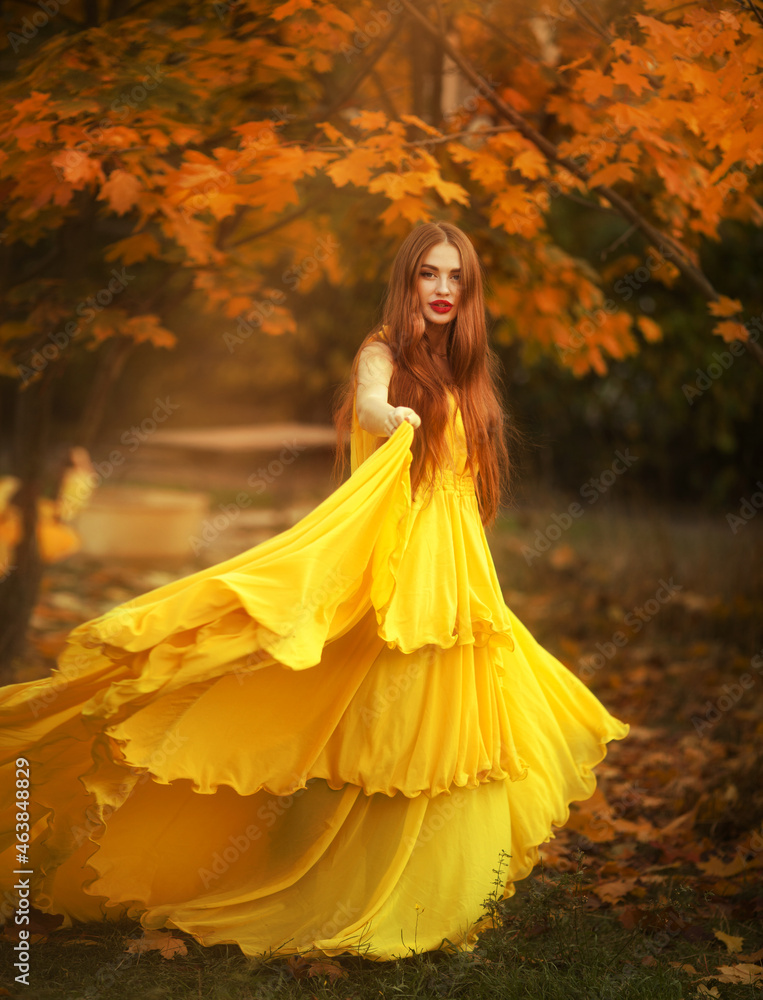 beautiful girl with red hair walks in the autumn forest.