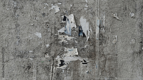 old paper glued to the concrete wall. scraps of paper on the wall