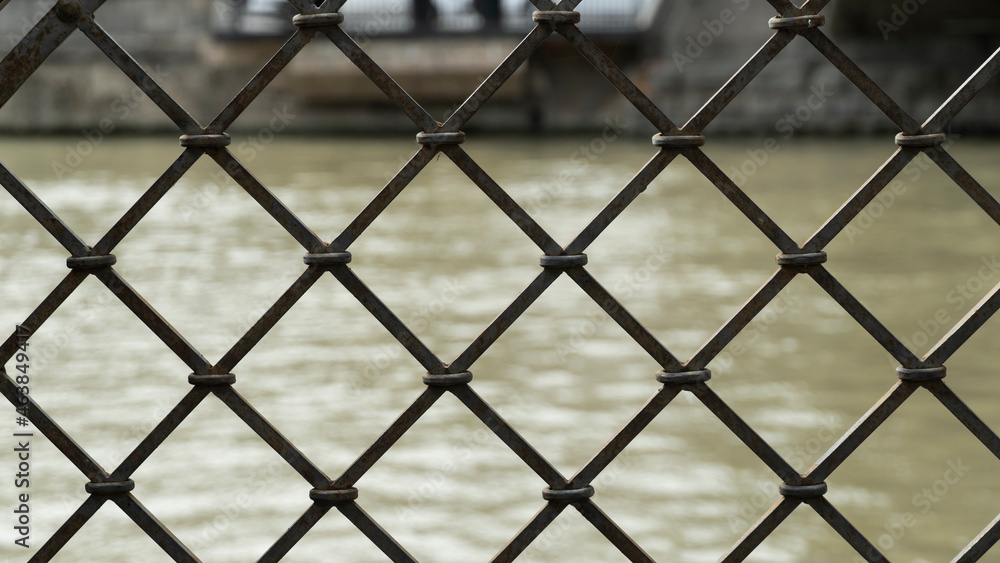 Fototapeta premium iron grill. the river can be seen through the gratings. prison concept