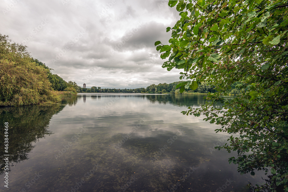 View over a Dutch lake on a windless and cloudy day. The photo was taken at the end of the summer near the village of Raamsdonksveer, municipality of Geertruidenberg, province of North Brabant.