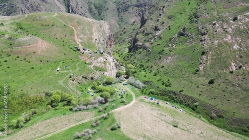 Aerial view camping area. Drone's camera fly over cars and  tents, that are located in in the gorge. Aerial footage family, resting place. Hiking place for hikers, extremals in Armenia.  photo