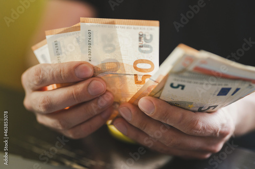 business man counting money. rich male hands holds and count cash banknotes of 50 euros bills or notes currency