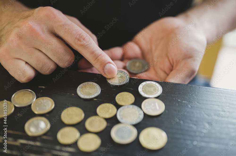 business man counting money. rich male hands holds and count coins of different euros on table business man counting money. rich male hands holds and count coins of different euros on table