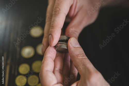 business man counting money. rich male hands holds and count coins of different euros on table