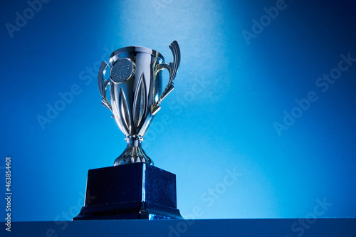 Fototapeta low angle view of winning trophy against blue background