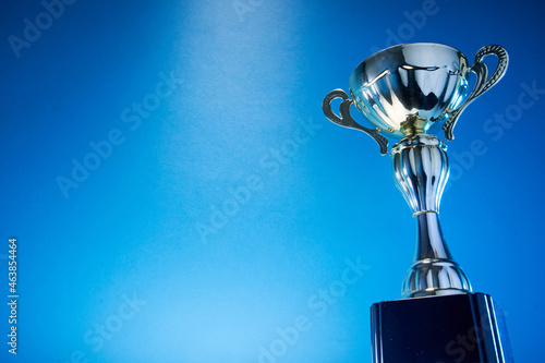 low angle view of winning trophy against blue background photo