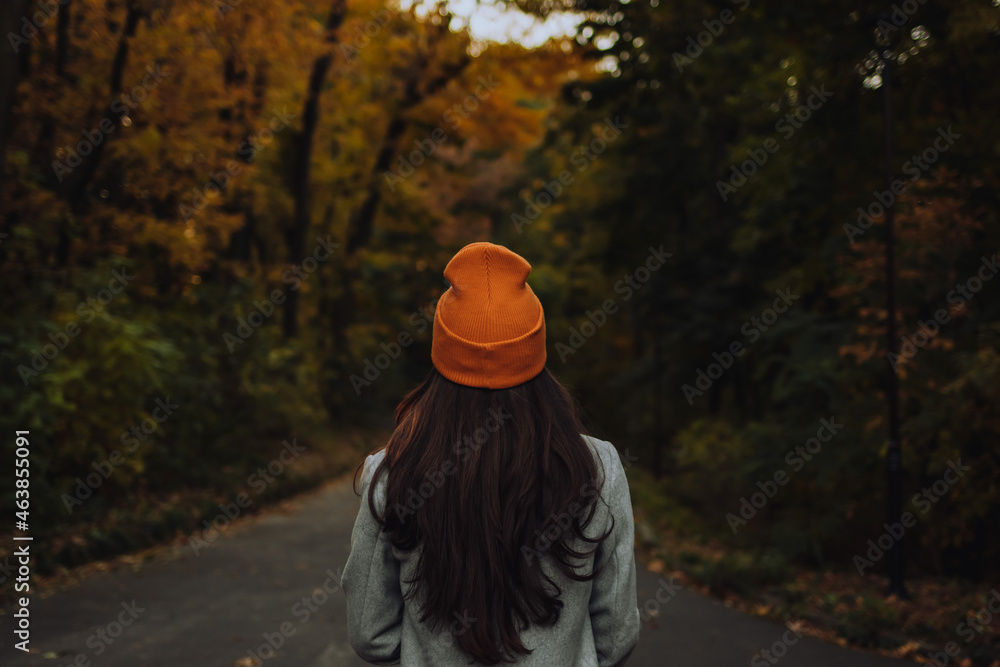 Back view of young girl walking alone on the street in autumn Back view of young girl walking alone on the street in autumn