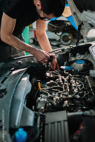 Car mechanic in a workshop working at car © noeliauroz