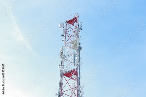 Frozen Cellular Tower in the mountains. Telecommunications tower with many different antennas for signal transmission. Sunny winter day. Winter industrial landscape. Bright sunlight