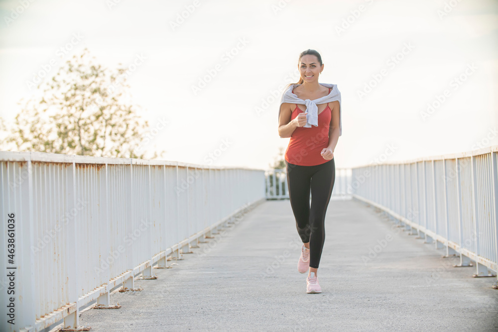 Fitness woman running on city road Fitness woman running on city road