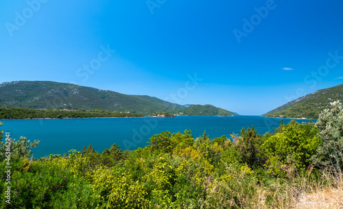 View of beautiful Croatia coast near Makarska. Blue sea with white beach. Isles in the background. Summer weather, blue sky. © Martin
