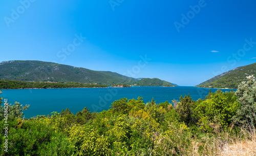 View of beautiful Croatia coast near Makarska. Blue sea with white beach. Isles in the background. Summer weather, blue sky.