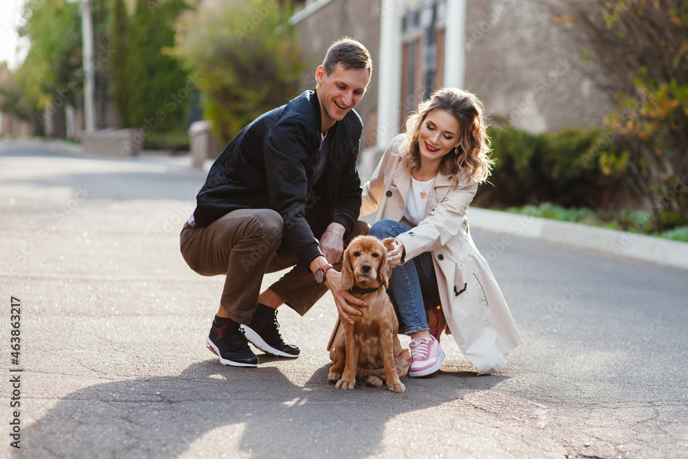 Fototapeta premium Young couple walking down stairs with their dogs on a city street