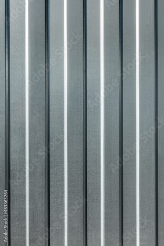 Vertical metal sheet made of galvanized profiled flooring. The texture and pattern of the metal background.