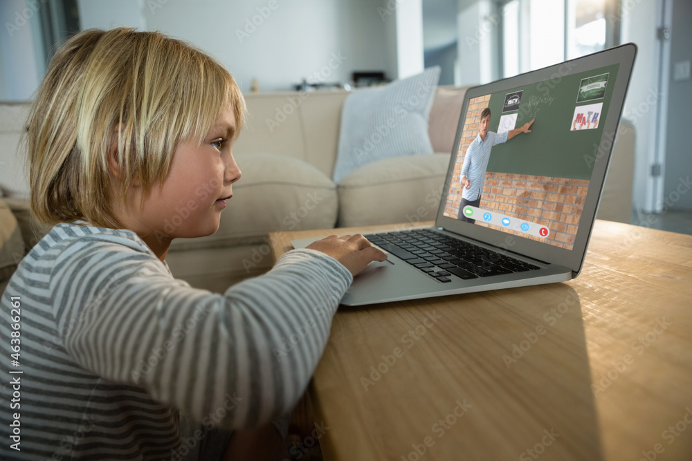 Caucasian boy using laptop for video call, with caucasian male teacher on screen Caucasian boy using laptop for video call, with caucasian male teacher on screen