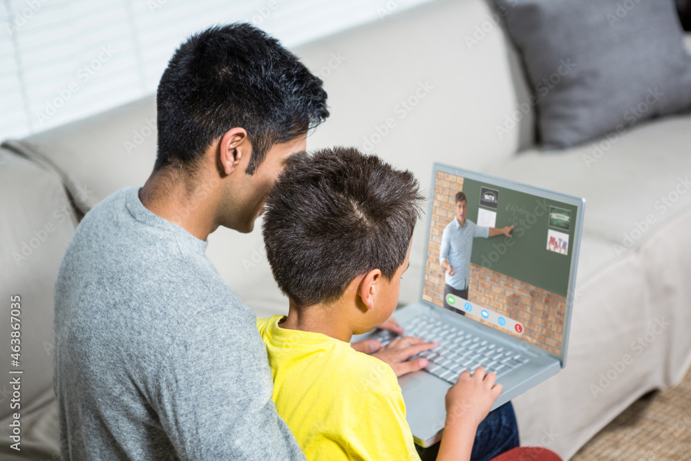 Biracial boy with father using laptop for video call, with male teacher on screen Biracial boy with father using laptop for video call, with male teacher on screen