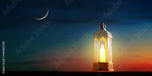 Muslim holy month Ramadan Kareem - Ornamental Arabic lantern with burning candle glowing with crescent moon