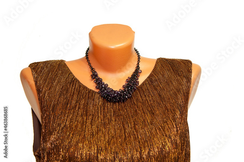 Women's jewelry women's beads, necklace. on a mannequin in a woman's brown jacket . On an isolated white background 